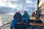 Gasten zitten aan dek van de Johanna Engelina tijdens het zeilen