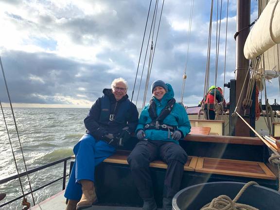 Gasten zitten aan dek van de Johanna Engelina tijdens het zeilen