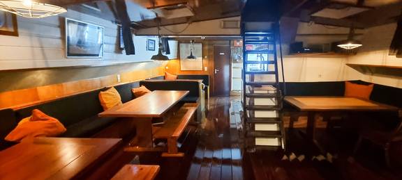Salon van de Johanna Engelina met eettafels en trap naar het dek