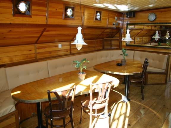 Zithoek met houten eettafel in de salon van de Korevaer