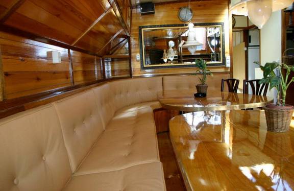 Zithoek met houten eettafel in de salon van de Korevaer