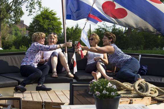 Gasten proosten aan dek van de Magnifique II