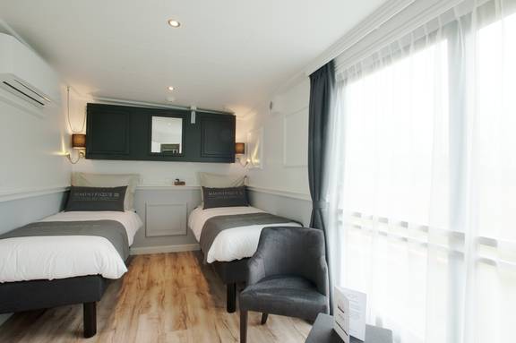 Suite met twee bedden en grote ramen aan boord van de Magnifique III