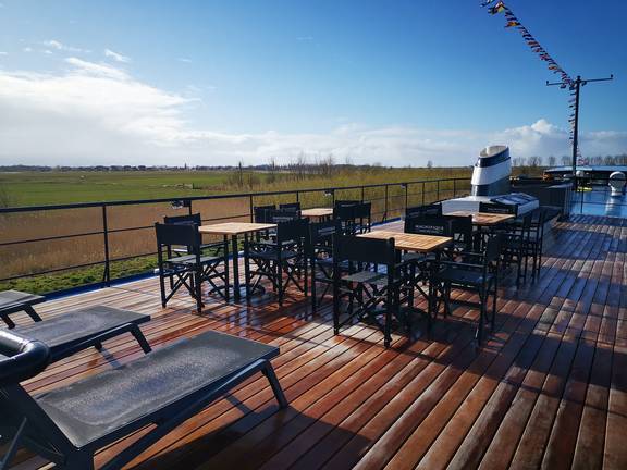 Zonnedek met tafels en ligstoelen van de Magnifique IV