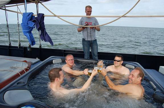 Gasten proosten in de jacuzzi op het dek van de Mare fan Fryslân
