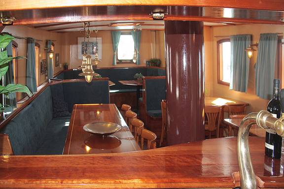 Salon van de Mars met houten tafels en groene zitbanken