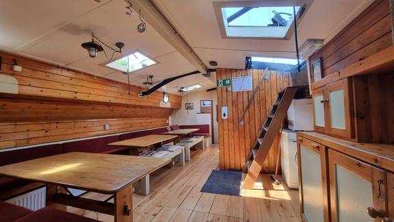 Overzicht van de salon van de Medusa met houten tafels en dakramen