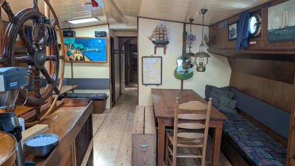 Salon van de Meridiaan met houten tafels en blauwe zitbanken