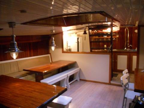 Houten eettafels en banken in het dagverblijf van de Nieuwe Zorg