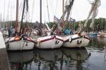Tjalk Pelikaan afgemeerd tussen andere schepen in de haven