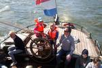 Gasten bij het stuurwiel op het achterdek van de Pelikaan