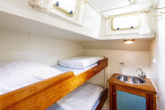 Lichte hut met stapelbed en wastafel op de Pelikaan