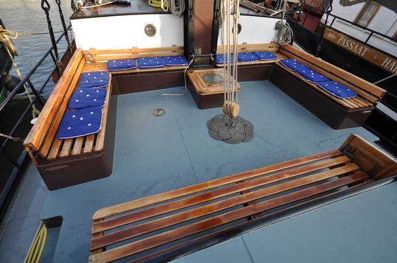 Houten banken met blauwe kussens in de zitkuip van de Poseidon