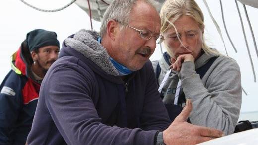 Schipper Arno van Aartrijk geeft uitleg aan een gast aan dek