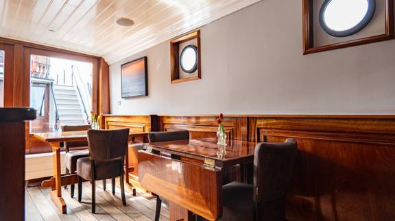 Zithoek met houten tafel en stoelen op de Simmer fan Fryslân