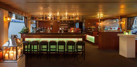Ruime salon van de Smaragd 1 met bar en groene barkrukken