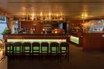 Ruime salon van de Smaragd 1 met bar en groene barkrukken