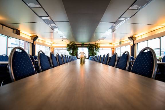 Lange vergadertafel met blauwe stoelen in de salon van de Smaragd 2