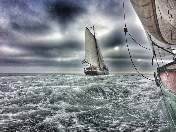Spartivento onder zeil op golvend water onder donkere wolken
