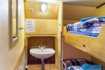 Tweepersoonshut met stapelbed en wastafel op de Spes Mea