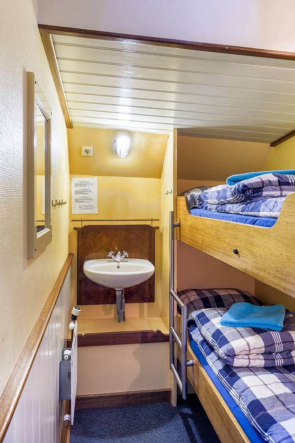 Tweepersoonshut met stapelbed en wastafel op de Spes Mea