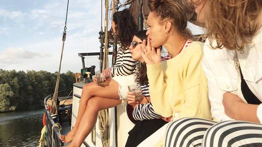 Vrienden genieten samen aan dek van een zeilschip