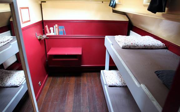Hut van de Sybaris met stapelbedden en rode zitbank