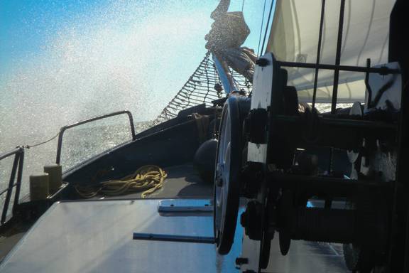 Water spat over het voordek van de Sybaris tijdens het zeilen