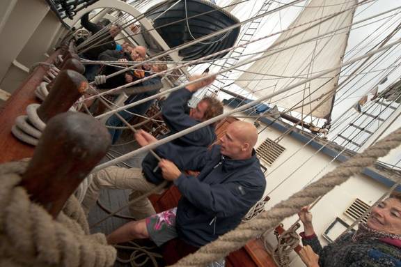 Zeilers werken samen aan dek van de Thalassa