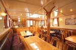 Salon van de Tsjerk Hiddes met houten tafels en leren zitbanken