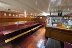 Salon van de Waterman met lange houten tafels