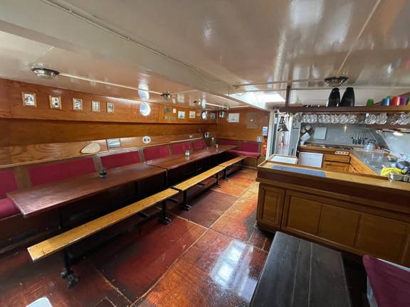 Salon van de Waterman met lange houten tafels
