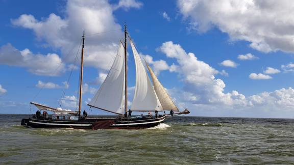Klipper Waterman met witte zeilen onder een blauwe lucht met wolken