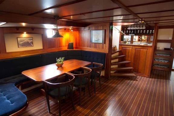 Zithoek met houten tafel in de salon van de Willem Barentsz