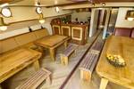 Salon van de Gulden Belofte met houten eettafels en zitbanken