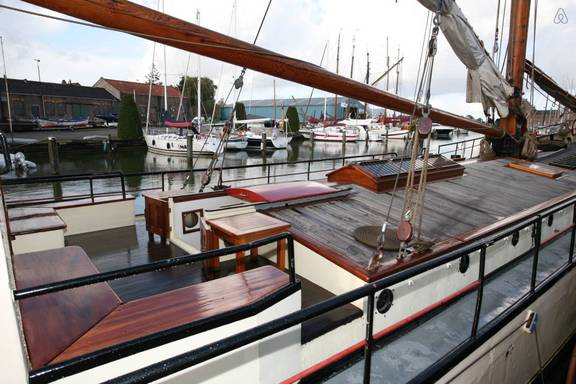 Zitbanken en houten tafel aan dek van De Lis