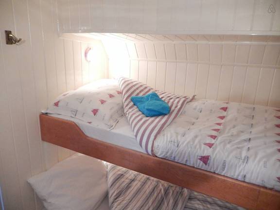 Stapelbed met gestreept beddengoed in een hut van De Lis