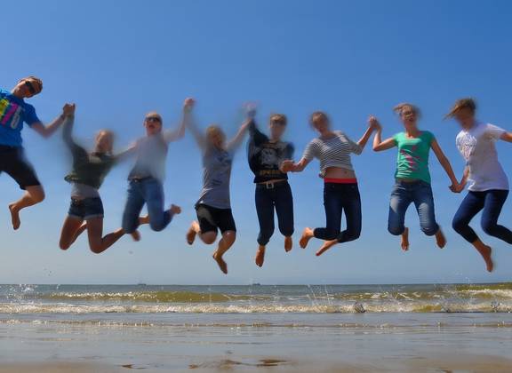 Groep scholieren springt op het drooggevallen Wad