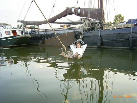 Gast in een hangmat boven het water naast de Vrouwe Jitske
