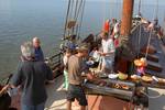 Gasten barbecueën aan dek van de Albatros tijdens het droogvallen op het Wad