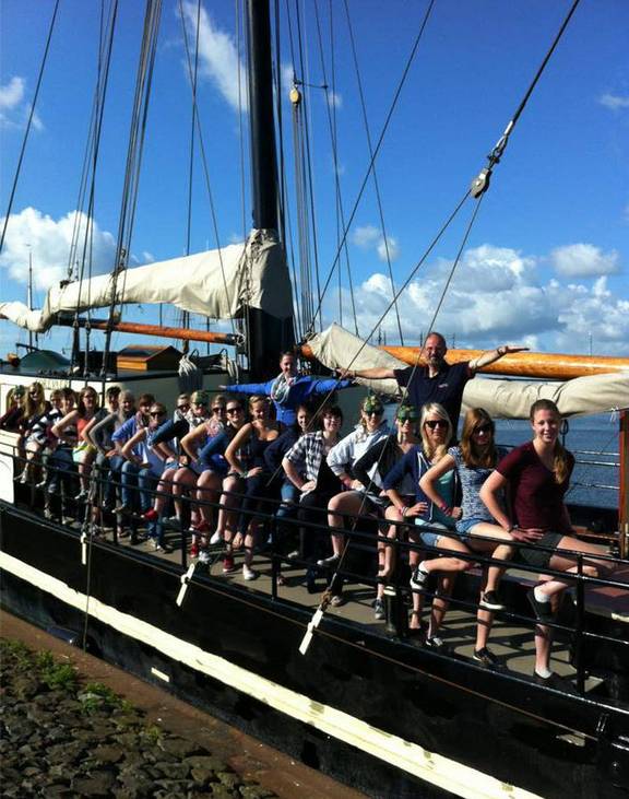 Groep scholieren aan dek van de Korevaer in de haven