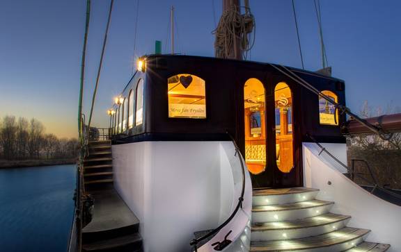 Verlichte ingang van de salon van de Mare fan Fryslân in de avond