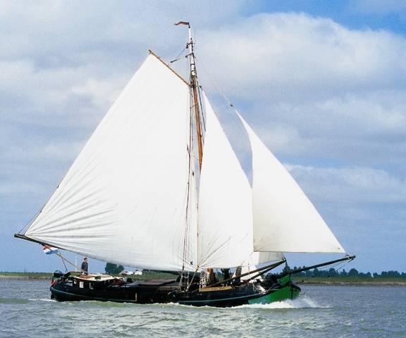 Tjalk Vrouwe Jitske onder witte zeilen op het water