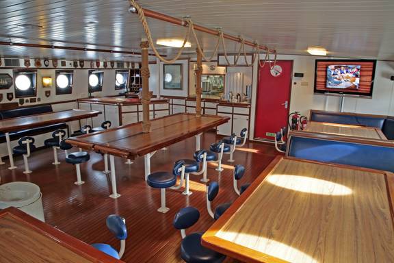 Houten eettafels in de ruime salon van de Eendracht