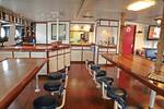 Salon van de Eendracht met lange houten tafels en vaste zitkrukken