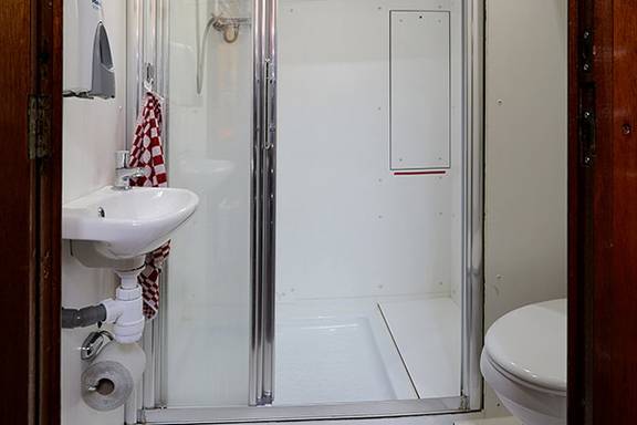 Wastafel, douche en toilet in de badkamer van de Orion