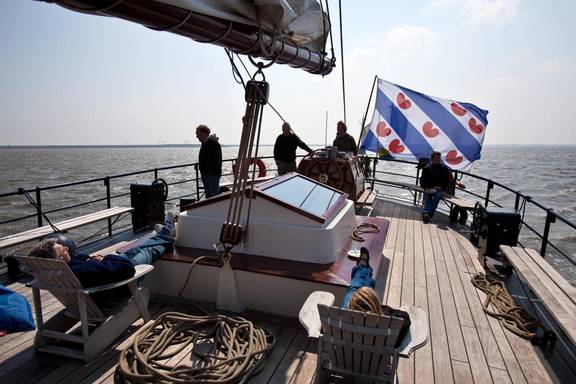 Gasten ontspannen op het achterdek van de Mare fan Fryslân